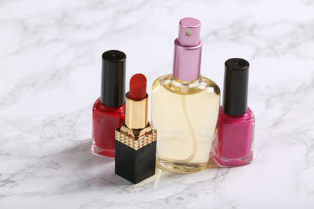 Nail polish bottles, perfume bottle and lipstick on marble background. beauty productsの写真素材