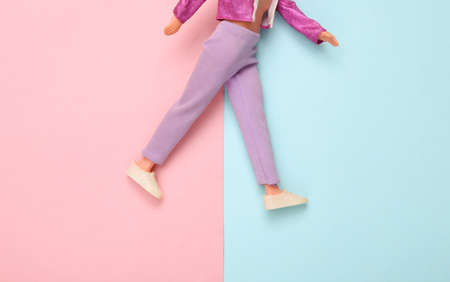Doll male legs in sneakers and trousers on a blue-pink pastel background. creative minimalist layoutの写真素材