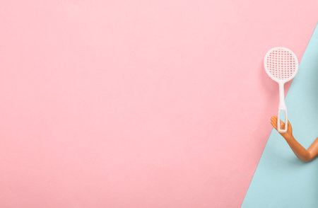 Doll hand holding tennis racket on blue-pink pastel background. Minmalism concept art. copy space