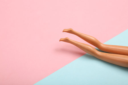 Doll female bare feet on a blue-pink pastel background. Sunbathe on the beach. creative minimalist layoutの写真素材