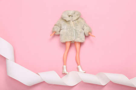 Woman Doll in fur coat on payment tape. Minimalism shopping concept. top view. flat layの写真素材