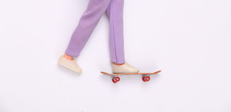 Doll legs ride on skateboard on white background. minimalismの写真素材