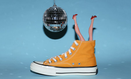 Disco ball and sneaker with doll legs on blue bright background. Minimalism party conceptの写真素材