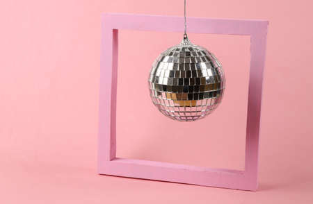 Disco ball with frame on pink background. Minimalist party concept