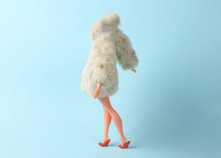 Doll mannequin in warm fur coat on a blue background. Minimalism fashion shot. concept artの写真素材