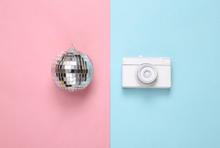 Camera with Disco ball on blue pink background. Minimalist party conceptの写真素材