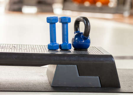 Dumbbells and kettlebells on a stepper platform. fitness equipment gym