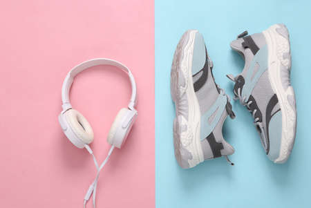Sports shoes and headphones on blue-pink pastel background. fitness concept. top view. minimalismの写真素材