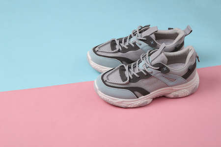 Sports sneakers on a blue-pink pastel background. running shoes. pastel color trendsの写真素材