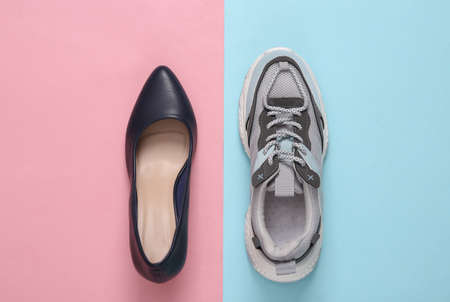 Sneaker and high heel shoe on a blue-pink background. top viewの写真素材