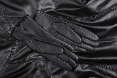 Black leather gloves on a leather surfaceの写真素材