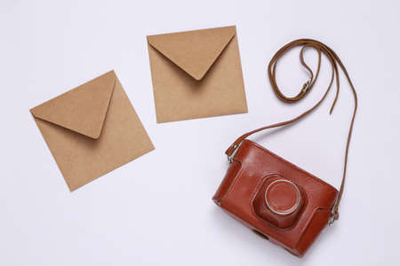 Craft envelopes and rerto camera on white background. top viewの写真素材