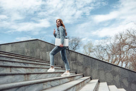 Young woman student climbs the stairs upの写真素材