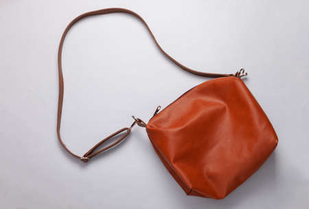 Leather brown messenger bag on a gray background