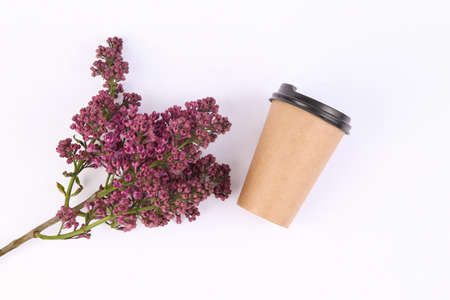 Blooming lilac and cup of coffee on white backgroundの写真素材