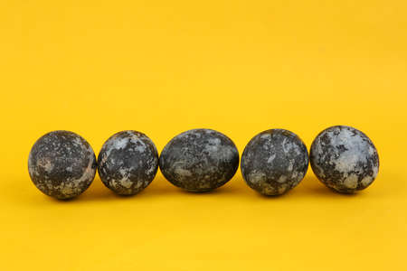 Gray marble painted Easter eggs on yellow backgroundの写真素材