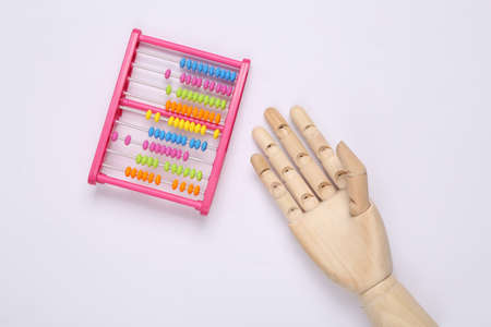 Childrens toy abacus and wooden hand on white background. top viewの写真素材