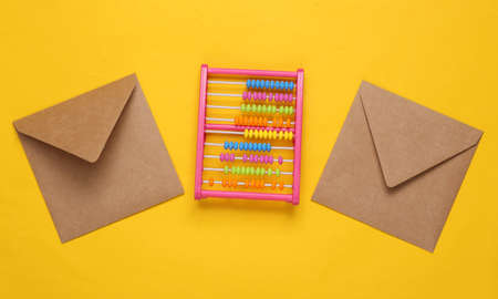 Envelopes and toy abacus on yellow backgroundの写真素材