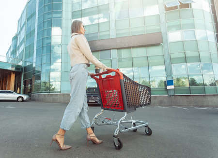 Wide angle of stylish lady with shopping trolley on background of shopping mall. lifestyleの写真素材