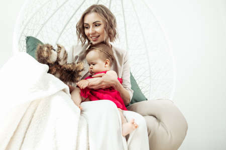 happy loving family. Mother and little daughter in living room. Cute mom and lovely baby have fun...