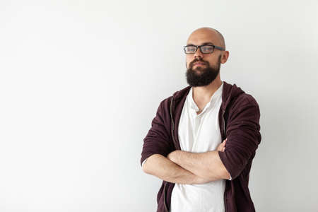 Portrait of a confident bearded bald handsome man in glasses on white backgroundの写真素材