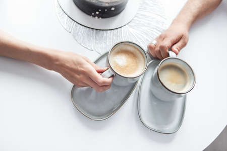 Hands are holding cups of coffee. romantic conceptの写真素材