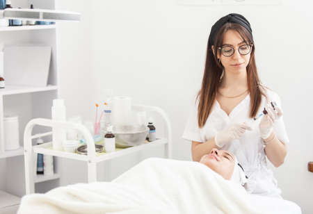 Cosmetologist does injections for anti wrinkle of beautiful woman. Women's cosmetology beauty salonの写真素材