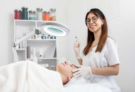 Cosmetologist does injections for anti wrinkle of beautiful woman. Women's cosmetology beauty salonの写真素材