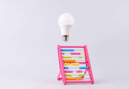 Colored abacus and a floating light bulb on a white background. idea conceptの写真素材