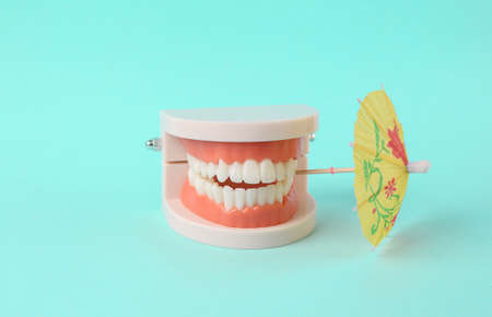 Cocktail umbrella in the teeth of the jaw model. Summer minimal concept