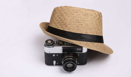 Straw hat with camera on white background. travel concept