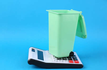 Calculator and trash can on blue background