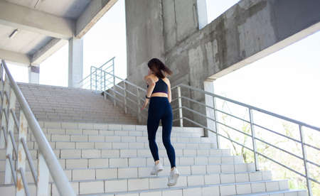 Fit woman runner runs up the stairsの写真素材