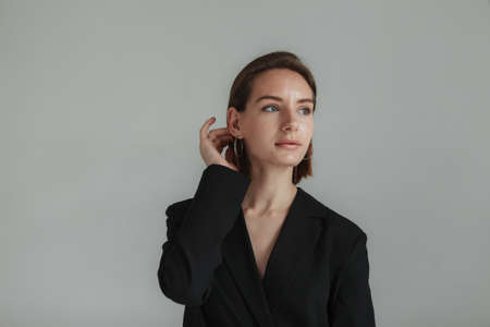 Portrait of a stylish young lady on a gray background. fashion shotの写真素材