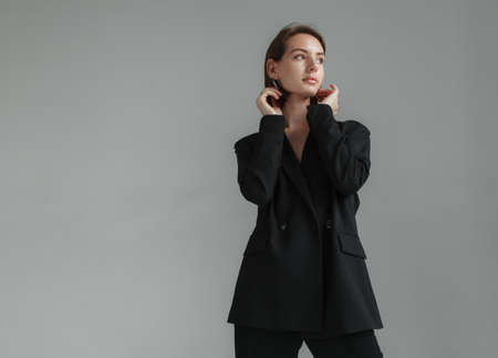 Sexy young woman in a jacket on a naked body and trousers in the studio. fashion snapshotの写真素材