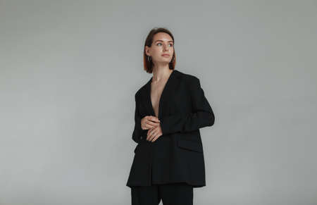 Sexy young woman in a jacket on a naked body and trousers in the studio. fashion snapshotの写真素材