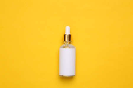 Mockup serum bottle on yellow background. Creative trendy beauty flat lay