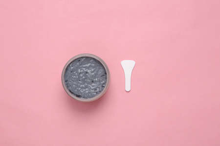 Jar of black clay for the face on pink backgroundの写真素材