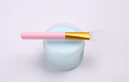 Jar of cream and brush on white background
