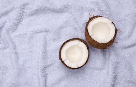 Two halves of coconut on a towel. top viewの写真素材