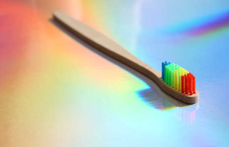 Bamboo rainbow toothbrush on colored holographic surfaceの写真素材