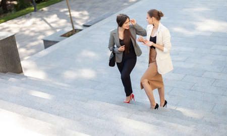 Two business women are discussing going up the stairsの写真素材