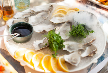 Fresh oysters in a shell, served on a plateの写真素材