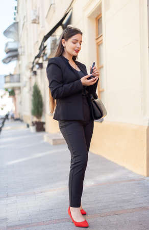 Young beautiful caucasian woman applying makeup with a brush in the cityの写真素材