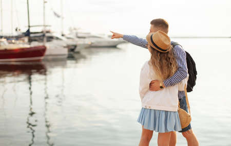 Couple in love spends time together against the backdrop of the yacht club. The guy points a finger pointing to the girl into the distance. love conceptの写真素材
