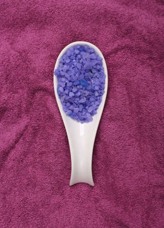 Spoon with lavender bath salt on pink towelの写真素材