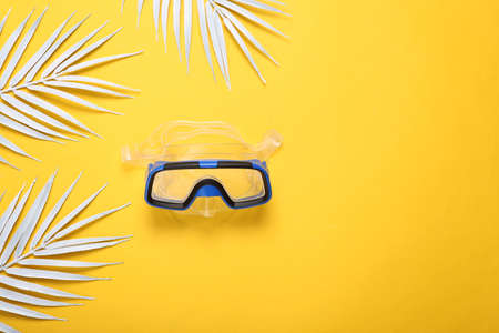 Diving mask with white palm leaves on yellow background. Travel concept, summer, vacation at sea....