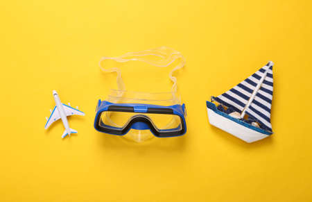 Diving mask with sailboat and air plane on a yellow background. travel conceptの写真素材