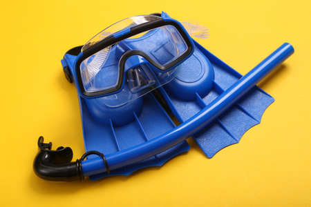 Children's fins, snorkel and diving mask on yellow background