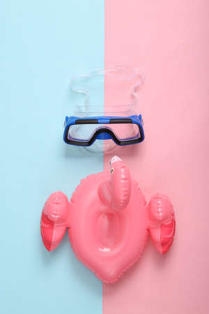 Diving mask with inflatable flamingo on blue pink pastel background